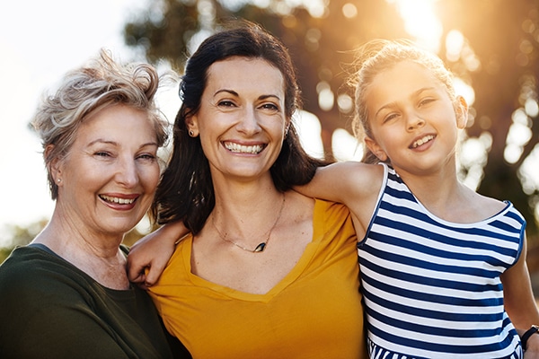 grandmother with her daughter and granddaughter smiling together