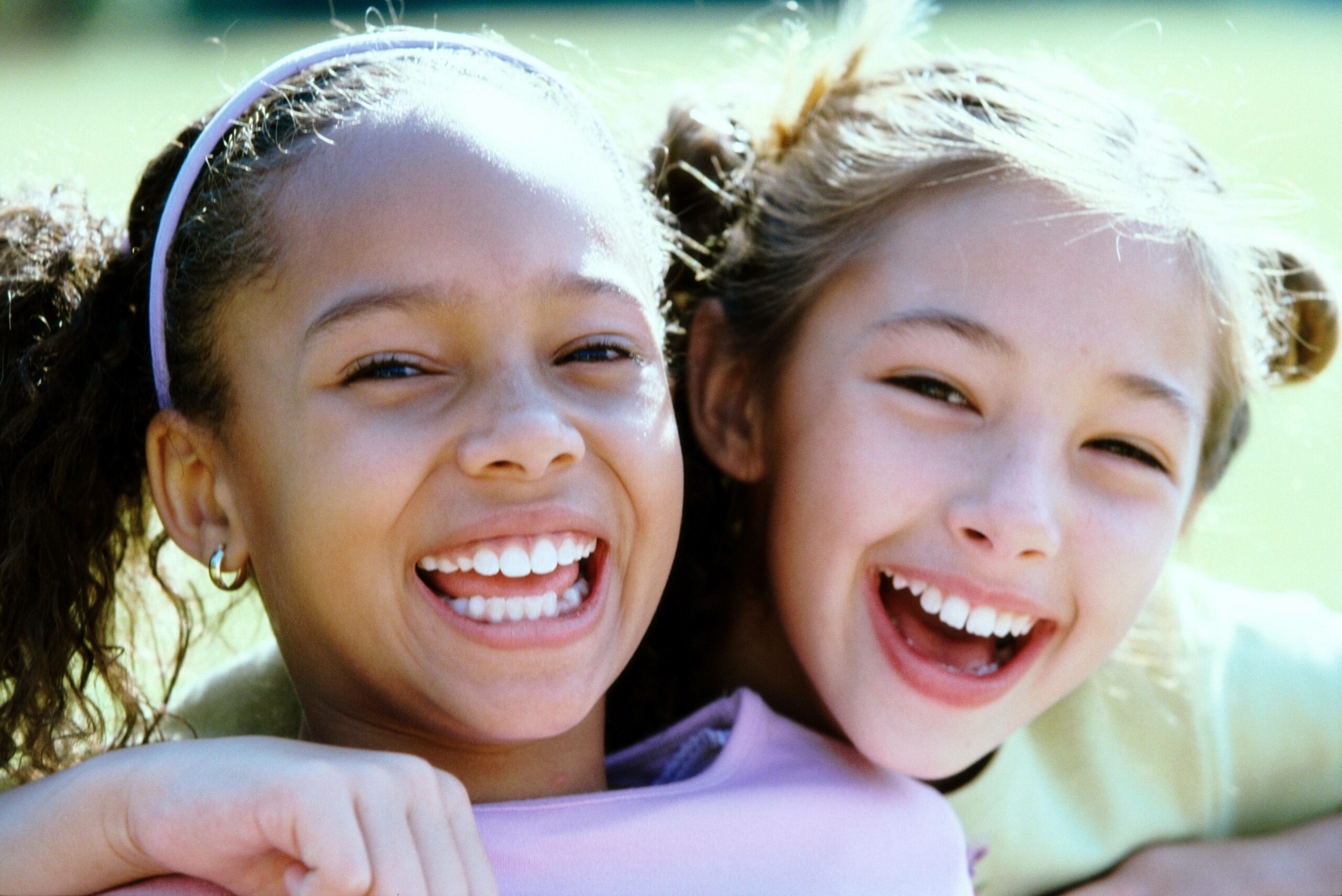 two young girls laughing and smiling