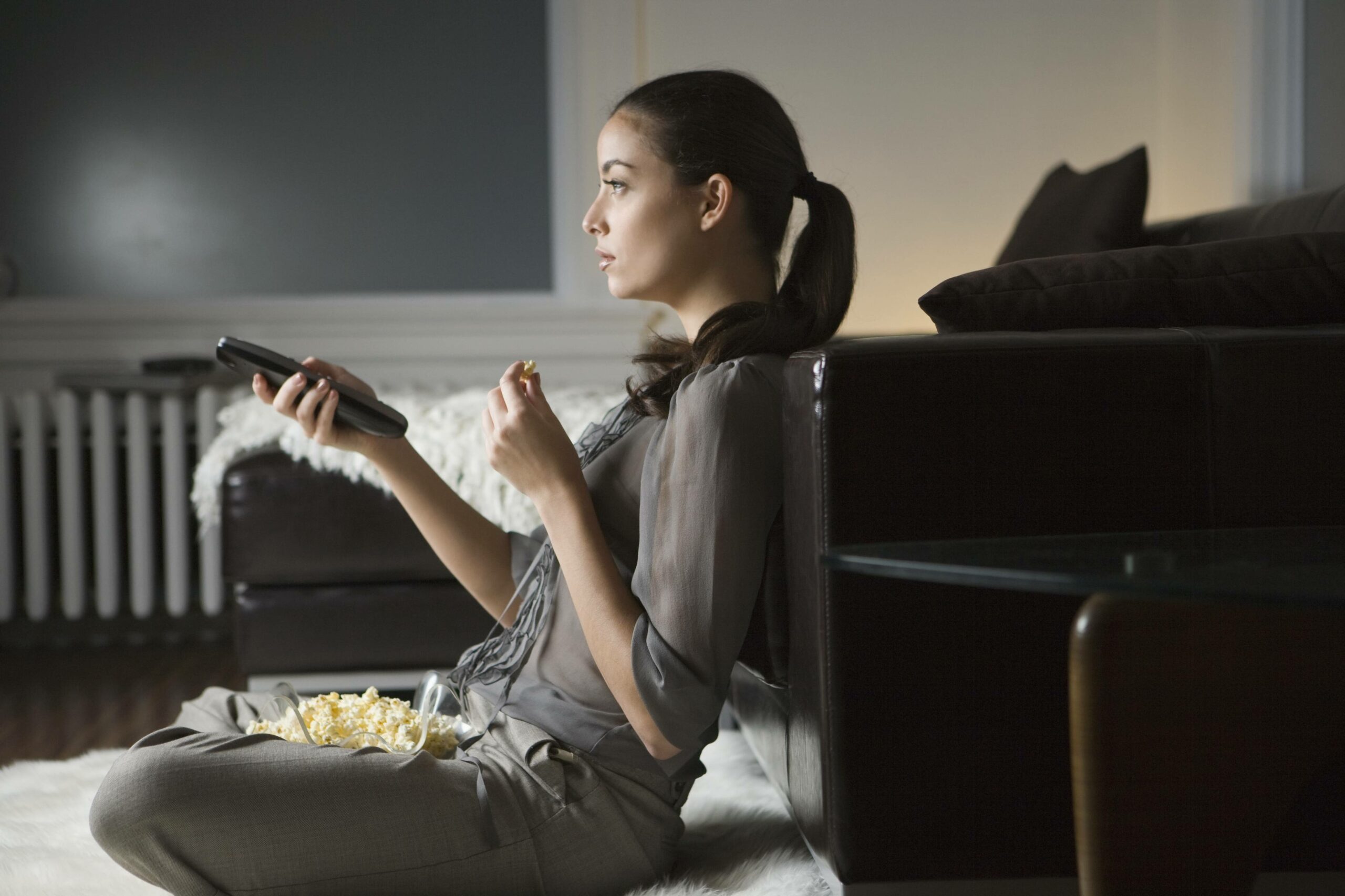 woman eating popcorn and watching tv