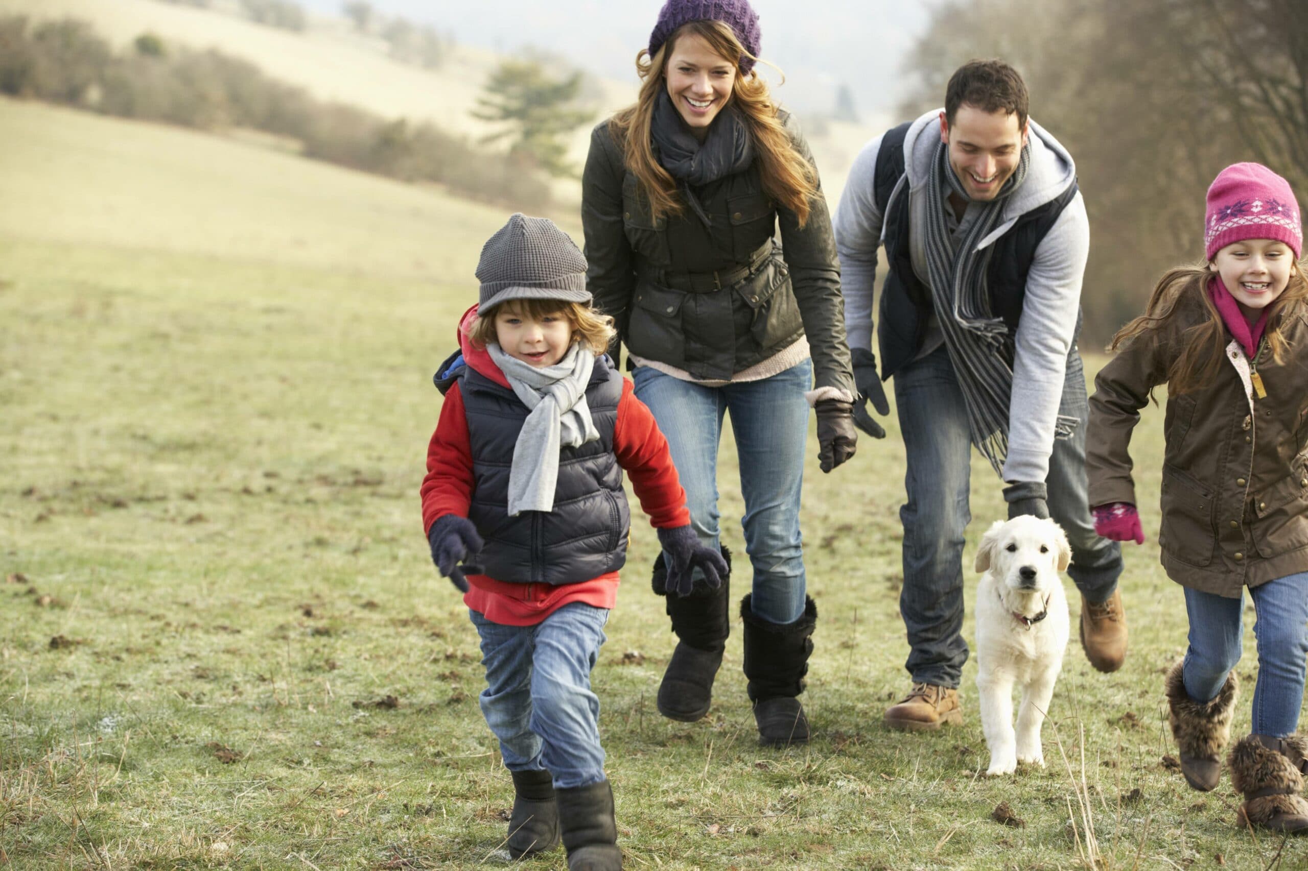family and dog all running together in cold weather