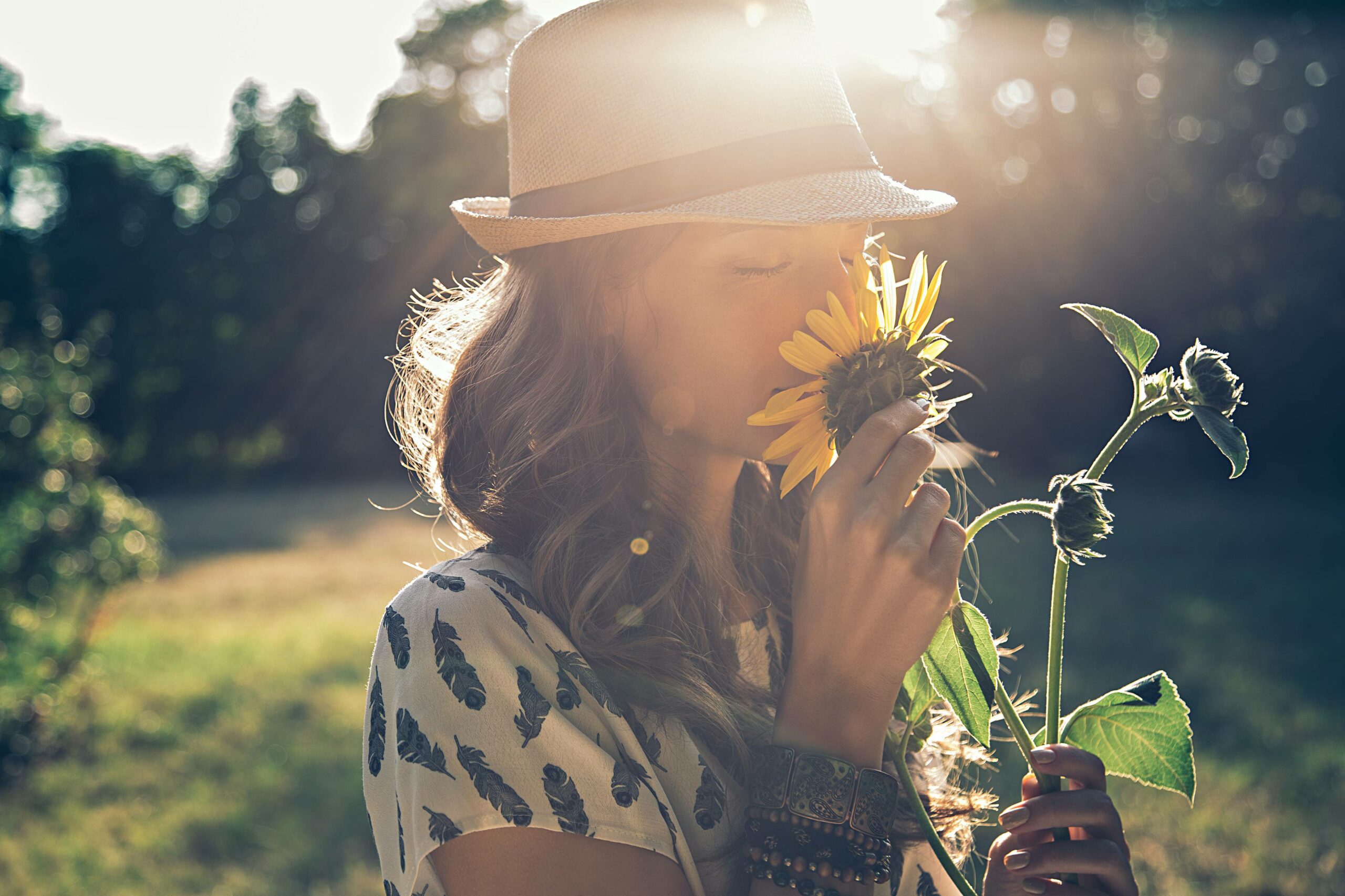 woman smiffing sunflowers