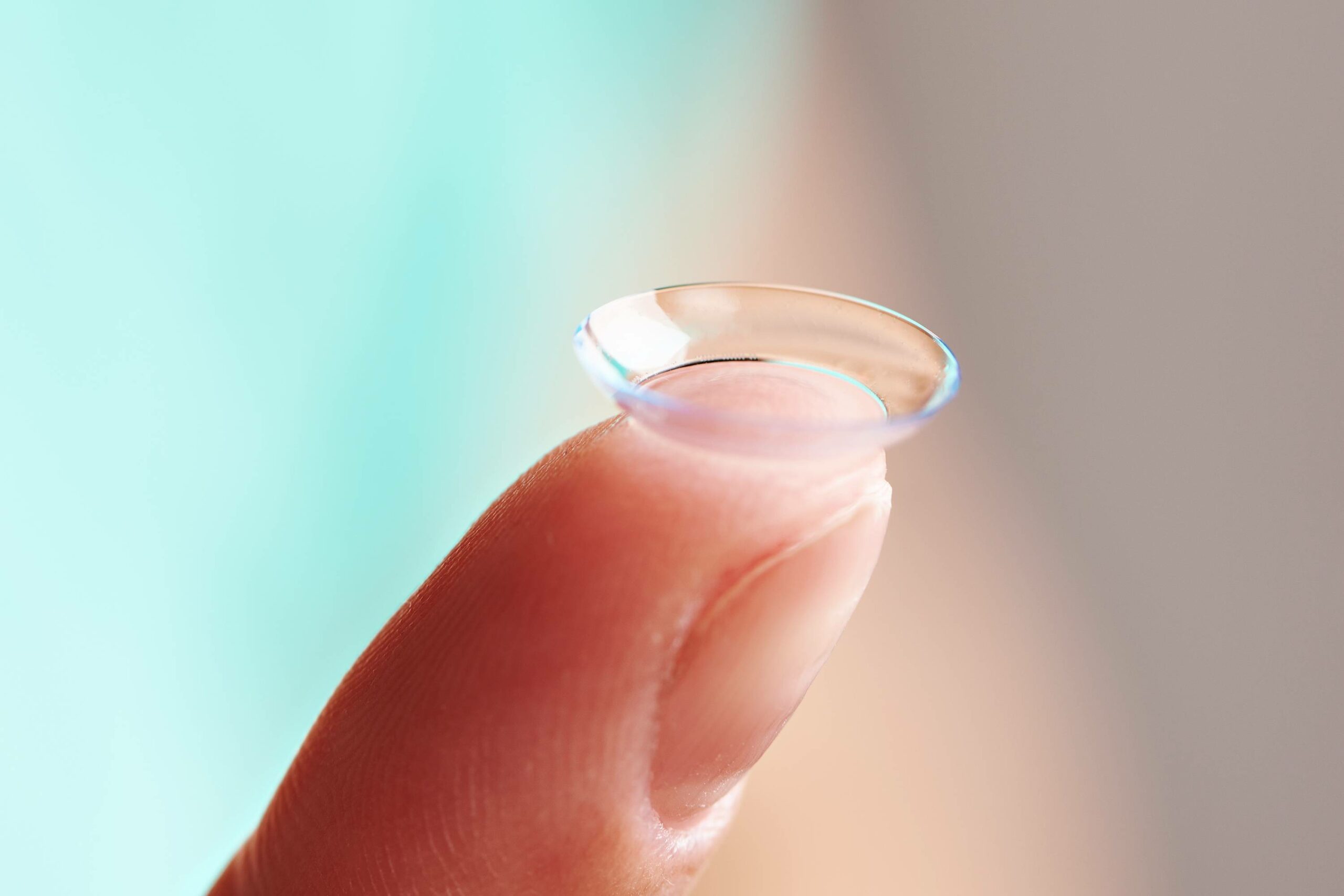 finger holding contact lens