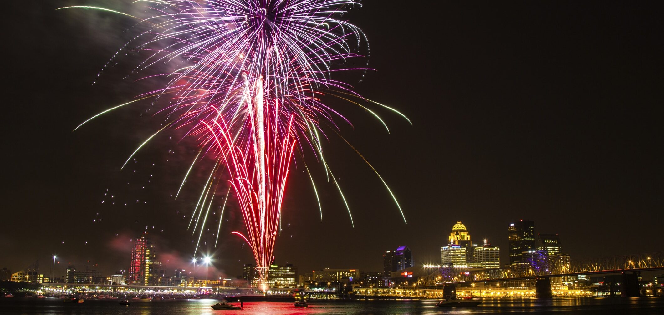 fireworks on the Ohio River with Louisville skyline and bridge in the background