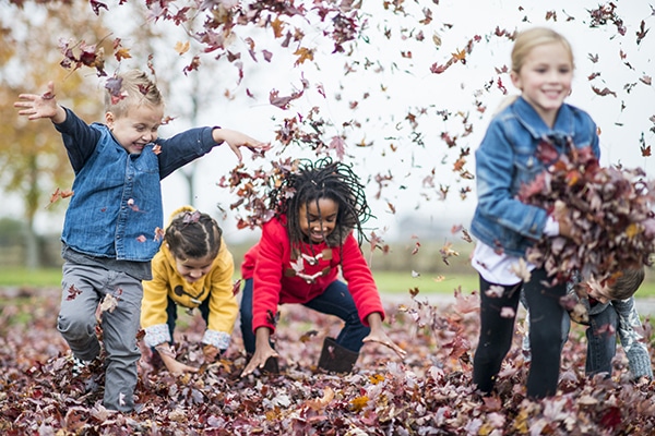 children playing in the leaves and running