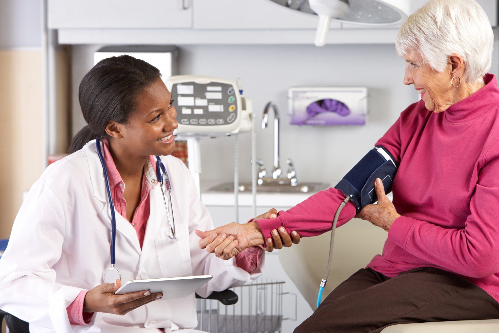 nurse taking patients blood pressure while holding her wrist