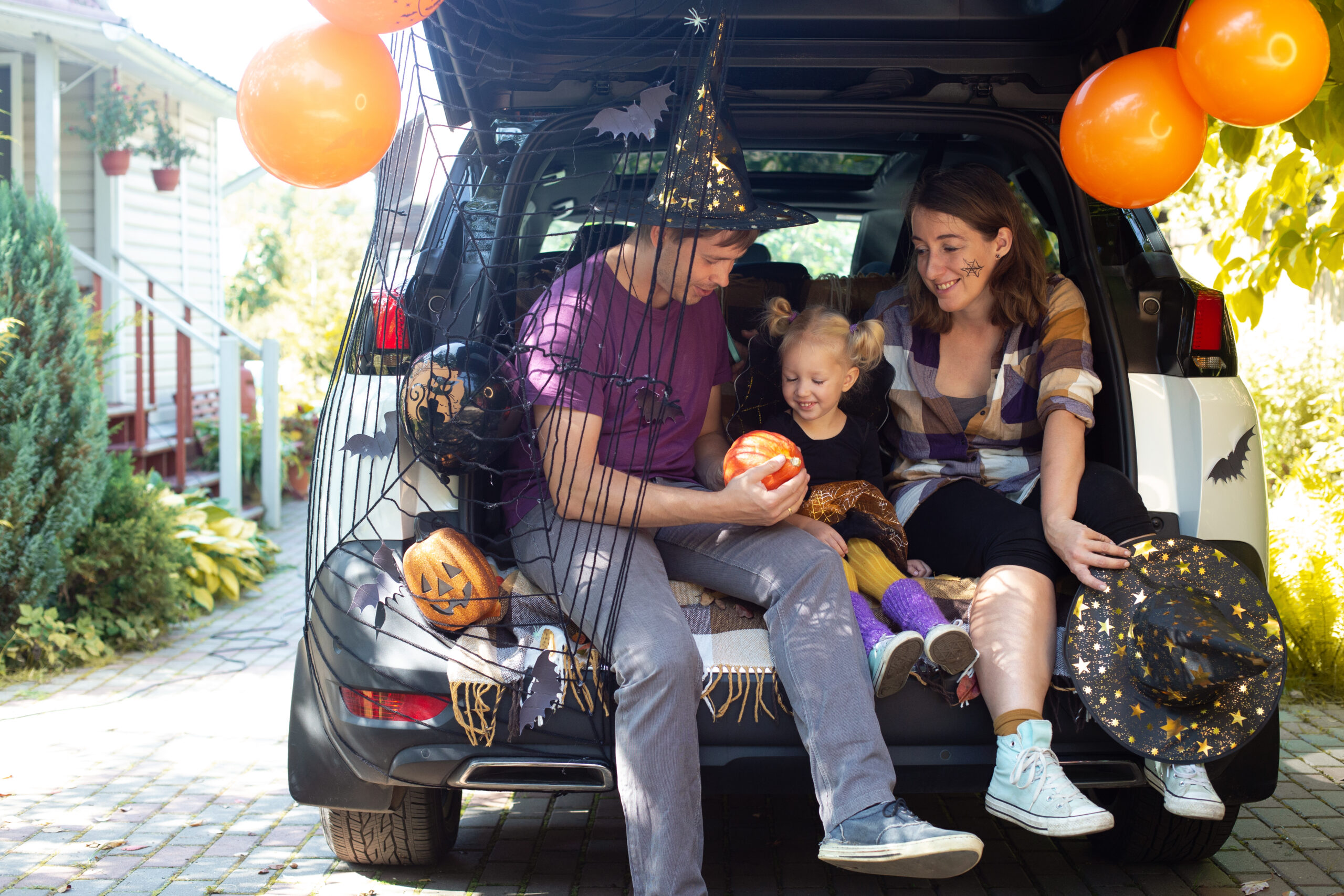 Family celebrating Halloween in car trunk
