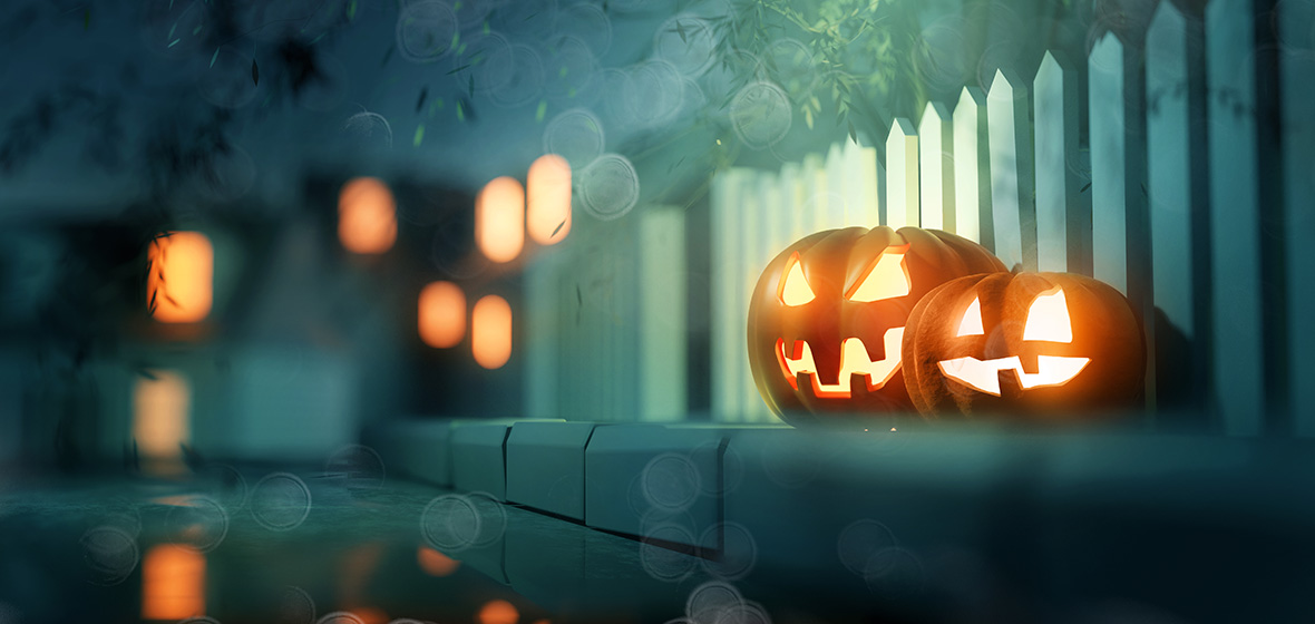 Glowing candle lit Jack O Lantern Halloween pumpkin decorations outside on a street pavement. 3D illustration.