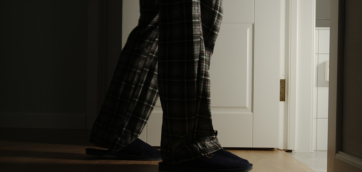 A person with bladder cancers walks to the bathroom at night