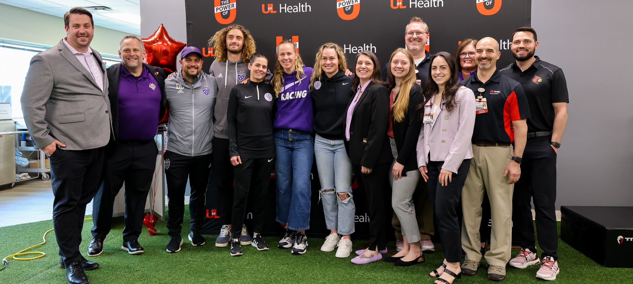 Group photo of LouCity FC, Racing Louisville FC coaches and UofL Health staff