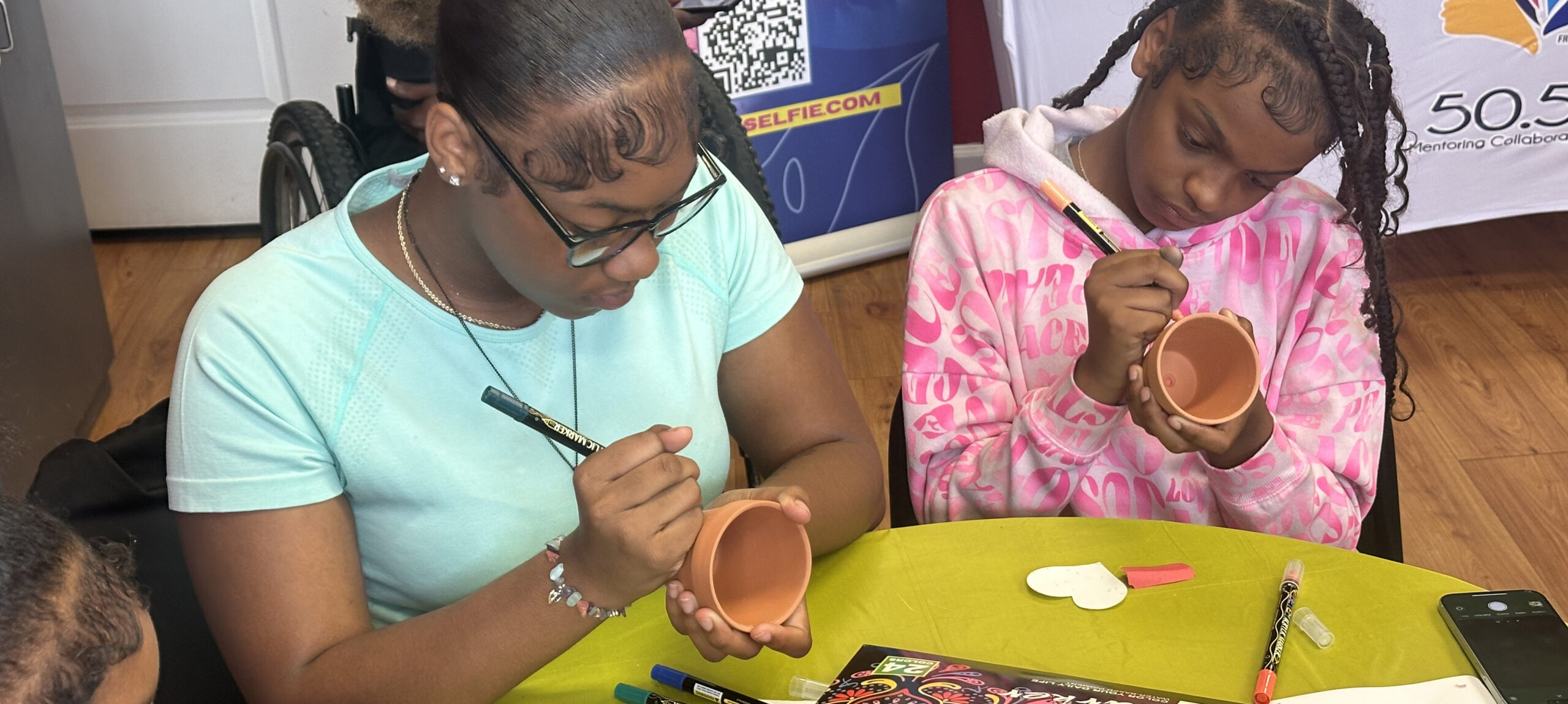 Two participants of UofL Health's Community Engagement Initiative for Gun Violence Prevention decorating clay pots as part of art therapy.
