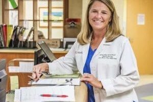A UofL Health employee smiling at the front desk